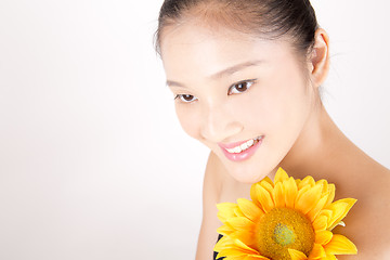 Image showing Beautiful young Asian girl with bright yellow sunflower