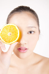 Image showing Beautiful young Asian girl holding orange slice over face