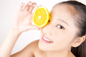 Image showing Beautiful young Asian girl holding orange slice over face