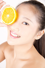 Image showing Beautiful young Asian girl holding orange slice over face