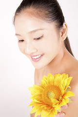 Image showing Beautiful young Asian girl with bright yellow sunflower