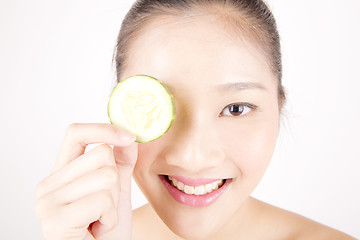 Image showing Beautiful young Asian girl holding cucumber slice over face