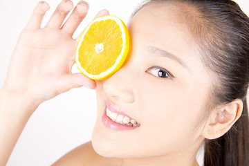 Image showing Beautiful young Asian girl holding orange slice over face