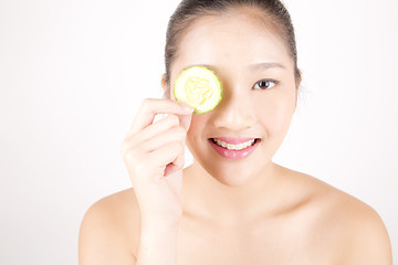 Image showing Beautiful young Asian girl holding cucumber slice over face