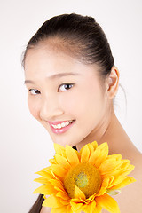 Image showing Beautiful young Asian girl with bright yellow sunflower