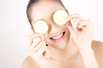 Image showing Beautiful young Asian girl holding cucumber slice over face