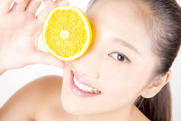 Image showing Beautiful young Asian girl holding orange slice over face