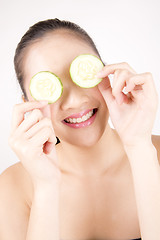 Image showing Beautiful young Asian girl holding cucumber slice over face