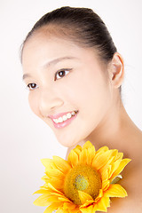 Image showing Beautiful young Asian girl with bright yellow sunflower