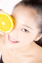 Image showing Beautiful young Asian girl holding orange slice over face