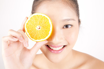 Image showing Beautiful young Asian girl holding orange slice over face