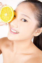 Image showing Beautiful young Asian girl holding orange slice over face