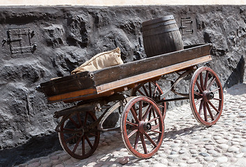 Image showing old wooden cart on background of brick wall