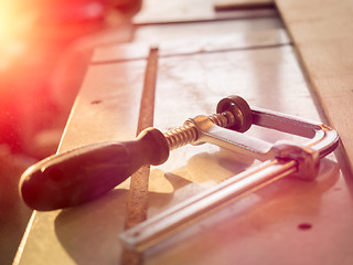 Image showing Real woodworking shop: clamps holding workpiece gluing, close-up