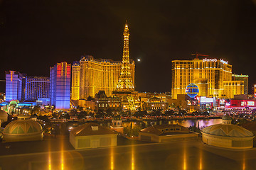 Image showing Night view of the dancing fountains of Bellagio and the Eiffel Tower replica of Paris Las Vegas Resort in Las Vegas Nevada, USA 