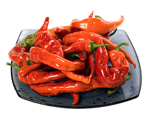 Image showing Wet red chili peppers on glass plate