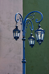 Image showing blue street lamp  and a green white  wall 