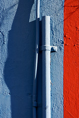 Image showing blue colored pipe and red wall 