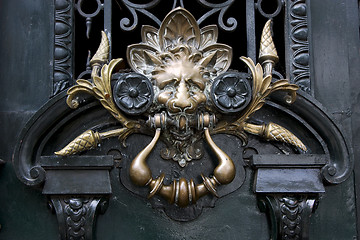 Image showing brass brown knocker in a green  door