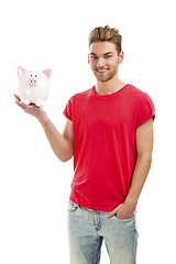 Image showing Handsome young man holding a piggy bank