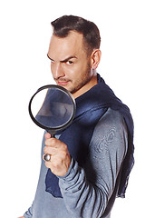 Image showing Serious man looking through magnifying glass