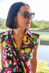 Image showing Young woman in sunglasses enjoying summer breeze at beach. 