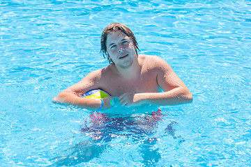Image showing Happy man with water ball in a swimming pool 