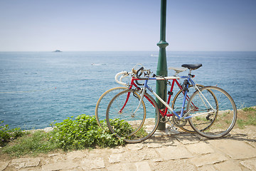 Image showing Two bikes tied to pole