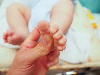 Image showing Baby receiving foot massage after diaper change with a thumb