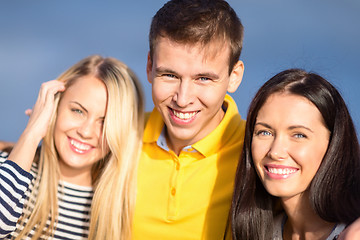 Image showing group of happy friends over sky background