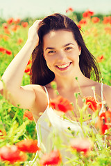 Image showing smiling young woman on poppy field