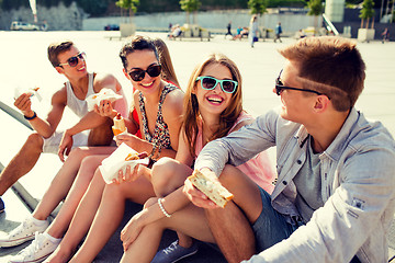 Image showing group of smiling friends sitting on city square