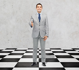 Image showing happy smiling businessman in suit shaking hand