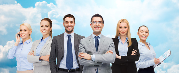 Image showing group of smiling businessmen over blue sky