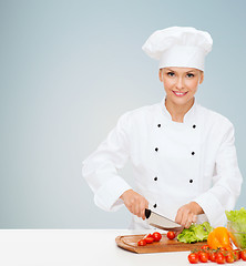 Image showing smiling female chef chopping vegetables