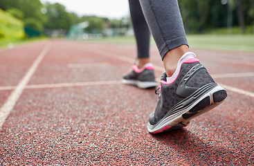 Image showing close up of woman feet running on track from back