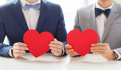 Image showing close up of male gay couple holding red hearts