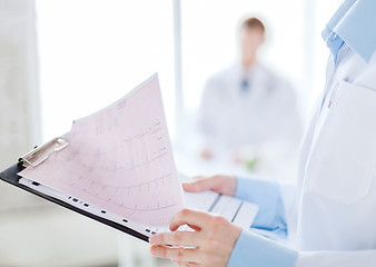 Image showing female holding clipboard with cardiogram