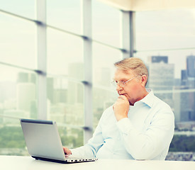 Image showing senior man in eyeglasses with laptop at office