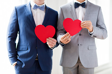 Image showing close up of male gay couple holding red hearts