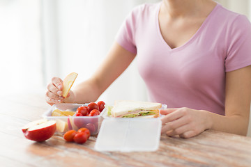 Image showing close up of woman with food in plastic container