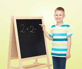 Image showing happy little boy with blackboard and chalk