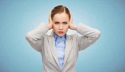 Image showing stressed businesswoman with covered ears