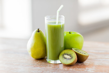 Image showing close up of fresh green juice and fruits on table