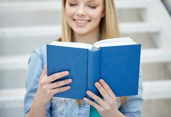 Image showing close up of young woman reading book at school