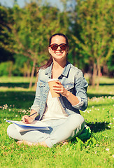 Image showing smiling young girl with notebook and coffee cup