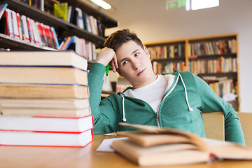 Image showing bored student or young man with books in library