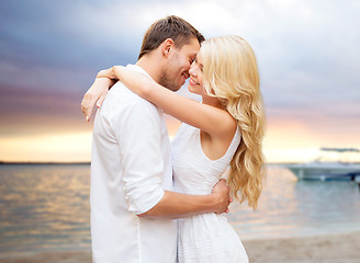 Image showing happy couple hugging over sunset at summer beach