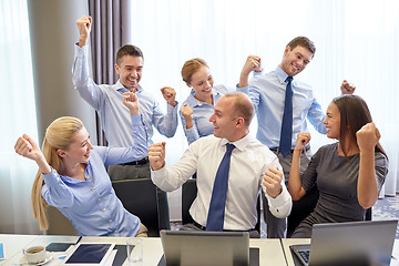 Image showing business people celebrating victory in office