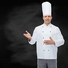 Image showing happy male chef cook inviting